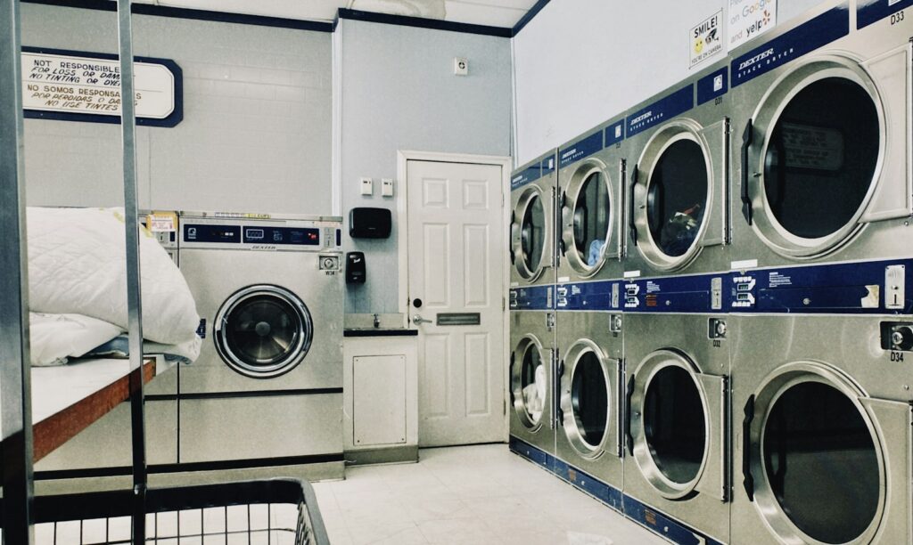 Lavanderia self-service em condomínio com lavadoras e secadoras comerciais empilhadas